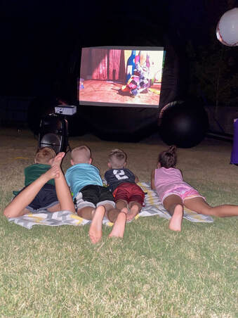 Kids watching a movie on the inflatable outdoor theater rental in Waco Texas.